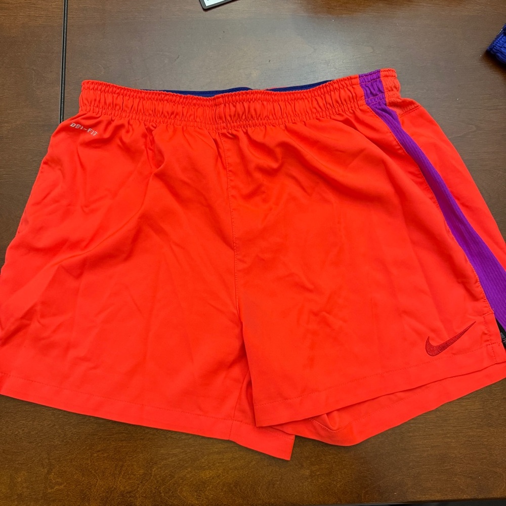 Nike Orange Shorts with purple side stripe accent.